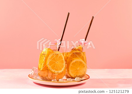 Modern still life with citrus fruits. Diet vegan cocktail with chia seeds, orange, lime, violet and ice. Detox diet and weight loss concept. Summer banner and screen template. 125121279