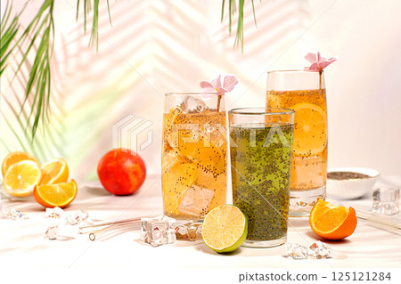 Modern still life with citrus fruits. Diet vegan cocktail with chia seeds, orange, lime, violet and ice. Detox diet and weight loss concept. Summer banner and screen template. 125121284
