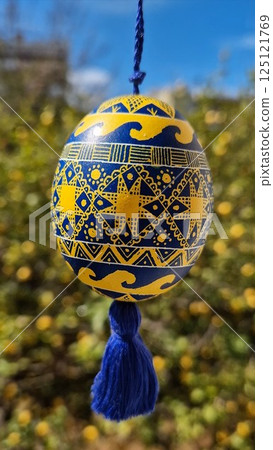 Colorful Easter eggs showcase traditional Ukrainian pysanka design featuring national colors yellow and blue in a vibrant outdoor setting 125121769