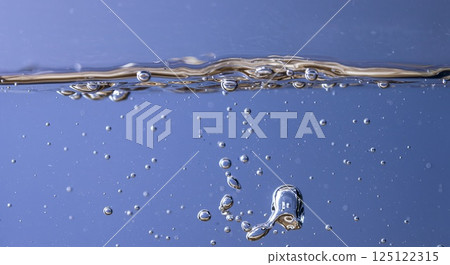 Lavender-infused water in glass with flowers on light background 125122315