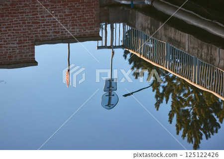 Water surface reflecting a street above 125122426