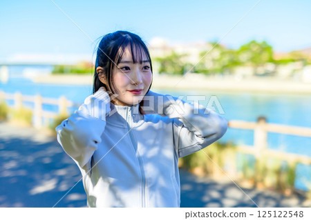 A cool woman walking in the city along the river Self-improvement Diet Walking Exercise 125122548