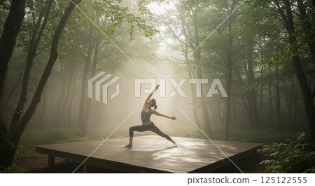 oman practicing yoga on forest deck in morning mist and sunlight 125122555