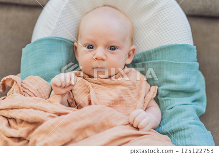 Newborn baby comfortably resting in a cozy baby nest. Safe and peaceful sleep concept for infants 125122753