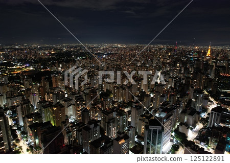 City skyline illuminated at night showcasing bustling urban life 125122891