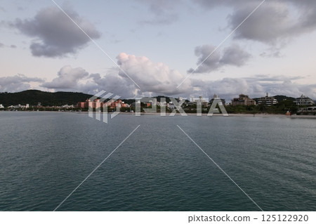 Sunset casts soft light over beachside resorts and tranquil waters 125122920