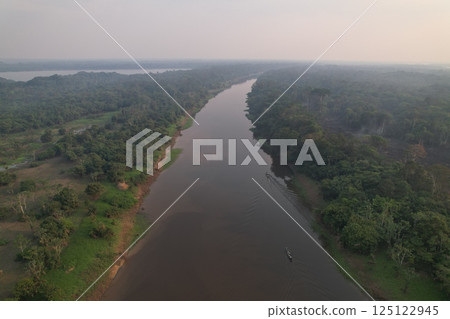 Amazon rainforest river winding through lush greenery at dusk Amazon rainforest river winding through lush greenery at dusk 125122945