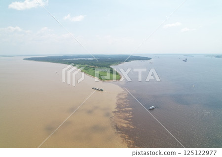 Majestic river confluence in the Amazon region on a sunny day Majestic river confluence in the Amazon region on a sunny day 125122977