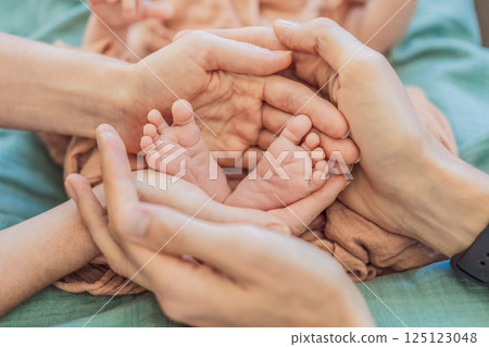 Newborn tiny feet surrounded by family. Symbol of love, protection, and strong family bonds. Parenthood, childhood, and unconditional love concept Newborn tiny feet surrounded by family. Symbol of love, protection, and strong family bonds. Parenthood, childhood, and unconditional love concept 125123048