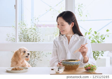 一位女士和她的狗一起享用美食 125123285