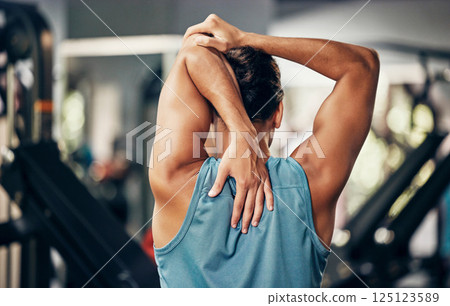 Fitness, man and stretching back in gym for health, wellness and flexibility. Sports warm up, arm stretch and male athlete preparing body muscles for exercise, workout or training in fitness center. 125123589