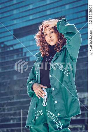 Black woman, hip hop and street model in city with modern fashion clothes, urban style and edgy clothing. Portrait of confident gen z beauty, cool girl by town building and relax in summer sun alone 125123603