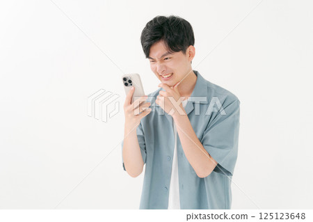 A young man operating a smartphone A young man operating a smartphone 125123648