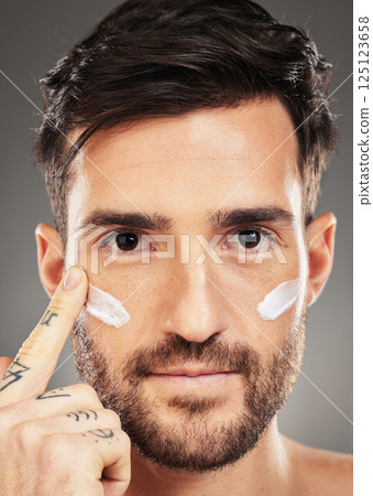 Portrait of man, skincare and cream product on face for natural skin wellness, cosmetic beauty and skin health in studio. Sunscreen, eye wrinkle protection and organic facial healthcare creme lotion Portrait of man, skincare and cream product on face for natural skin wellness, cosmetic beauty and skin health in studio. Sunscreen, eye wrinkle protection and organic facial healthcare creme lotion 125123658