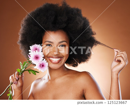 Black woman, flowers and natural beauty, afro hair and glowing skincare, organic makeup or eco dermatology on studio background. Portrait happy african model, curly hair and pink daisy blossom plants 125123667