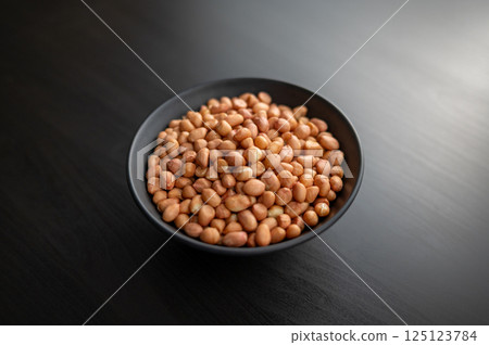 Healthy Snacking. A bowl of raw peanuts symbolizes a nutritious and protein-rich snack option. Healthy Snacking. A bowl of raw peanuts symbolizes a nutritious and protein-rich snack option. 125123784