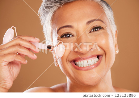 Portrait of senior beauty, rose quartz roller and woman with facial cosmetics face routine natural, healthy skincare treatment. Smiling elderly black lady, wellness massage product and organic spa 125123896