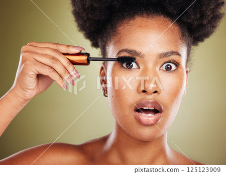 Black woman, surprise eyes and cosmetics mascara or makeup, natural beauty and skincare glow in studio. African girl model, facial cosmetology wellness and eyelash product care with shocked face 125123909
