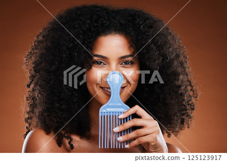 Beauty, hair care and portrait of black woman with comb for afro, natural and curly hair on brown background. Hair salon, cosmetics and girl with hair brush in hand for combing or grooming in studio Beauty, hair care and portrait of black woman with comb for afro, natural and curly hair on brown background. Hair salon, cosmetics and girl with hair brush in hand for combing or grooming in studio 125123917