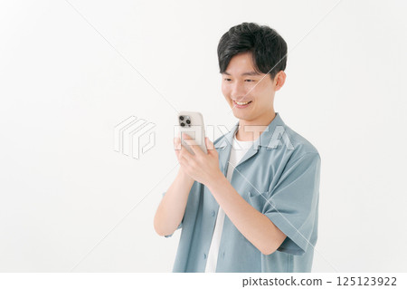 A young man operating a smartphone A young man operating a smartphone 125123922