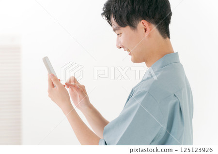 A young man operating a smartphone A young man operating a smartphone 125123926