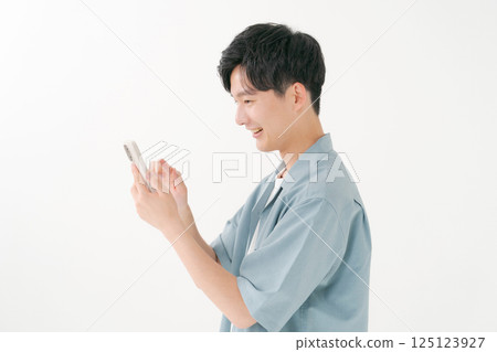 A young man operating a smartphone A young man operating a smartphone 125123927