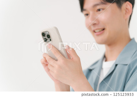 A young man operating a smartphone A young man operating a smartphone 125123933