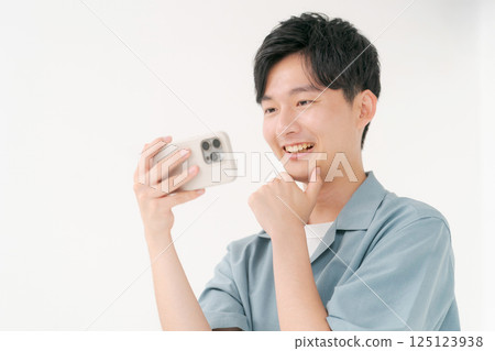 A young man operating a smartphone A young man operating a smartphone 125123938