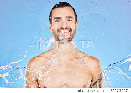Skincare, portrait and water splash of man in studio isolated on a blue background. Health, cleaning and male model from Canada bathing and washing for wellness, body care and fresh beauty routine. Skincare, portrait and water splash of man in studio isolated on a blue background. Health, cleaning and male model from Canada bathing and washing for wellness, body care and fresh beauty routine. 125123997