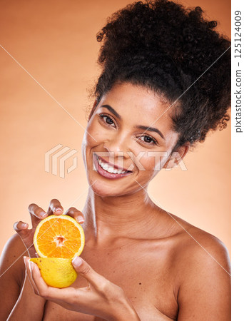 Black woman, afro hair and orange fruit on studio background for vitamin c skincare, dermatology or blemish treatment. Portrait, smile or happy beauty model with citrus health food for wellness diet Black woman, afro hair and orange fruit on studio background for vitamin c skincare, dermatology or blemish treatment. Portrait, smile or happy beauty model with citrus health food for wellness diet 125124009