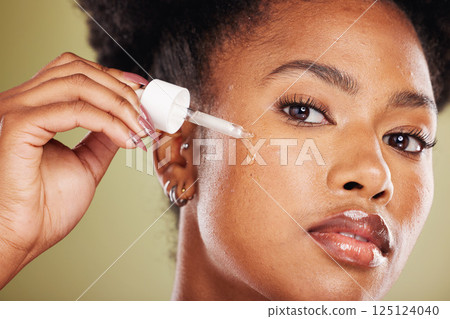 Black woman, dropper and face for skincare cosmetics, oil or hydration against a studio background. Portrait of African American female applying facial serum drops for healthy moisturizing treatment Black woman, dropper and face for skincare cosmetics, oil or hydration against a studio background. Portrait of African American female applying facial serum drops for healthy moisturizing treatment 125124040