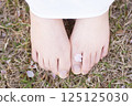 Cherry blossom petals and woman's feet 125125030