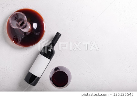 Decanter, glass and bottle with red wine on white. Flat lay 125125545