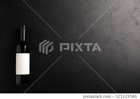 Bottle with red wine on black. Flat lay Bottle with red wine on black. Flat lay 125125560