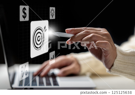 Business person with a laptop touching virtual target goal icons. Data management system. Smart corporate and technology innovation on virtual screen. Concept of business, finance, and global network Business person with a laptop touching virtual target goal icons. Data management system. Smart corporate and technology innovation on virtual screen. Concept of business, finance, and global network 125125638