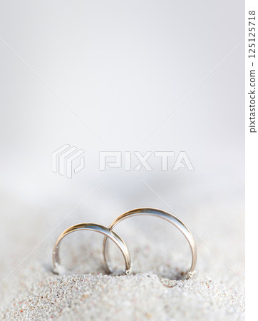 Wedding rings in sand on tropical beach, closeup 125125718
