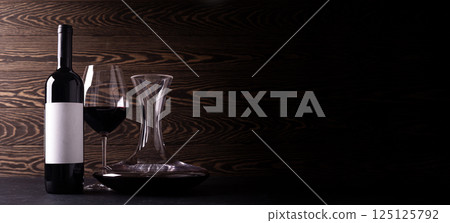 Decanter, glass and bottle with red wine on wooden rustic background Decanter, glass and bottle with red wine on wooden rustic background 125125792