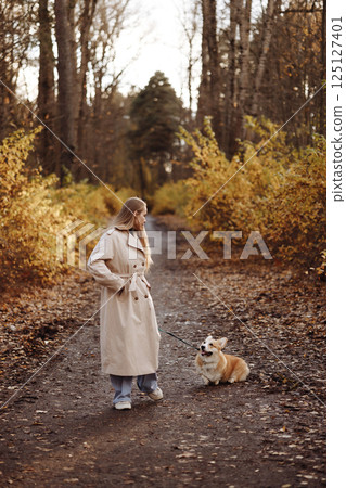 Woman with Corgi in Autumn Park 125127401