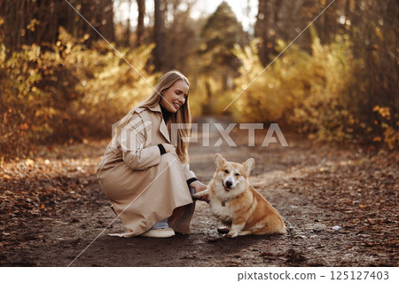 Woman with Corgi in Autumn Park Woman with Corgi in Autumn Park 125127403