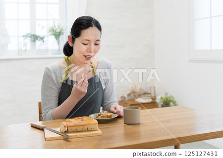 Woman tasting freshly baked cake 125127431