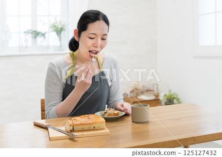 Woman tasting freshly baked cake 125127432