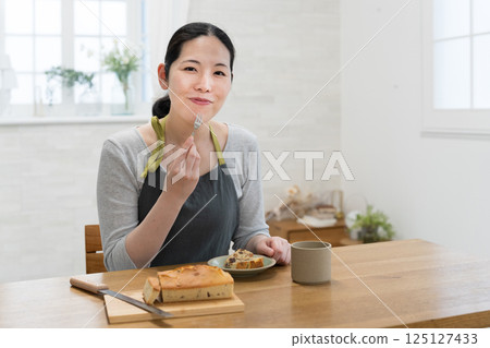 Woman tasting freshly baked cake 125127433