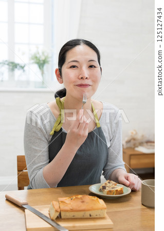 女人品嚐剛烤好的蛋糕 125127434