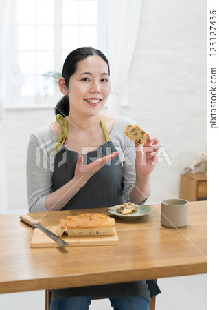 Woman tasting freshly baked cake Woman tasting freshly baked cake 125127436