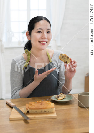 Woman tasting freshly baked cake 125127437