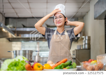 Young Chef Relaxing in Kitchen After Cooking Session 125127575