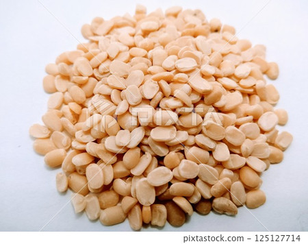 A picture of split black lentil without rind isolated on white background 125127714