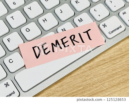 A sticky note with the word "disadvantage" written on it and a keyboard 125128653