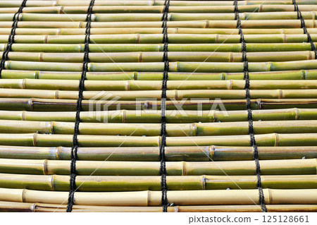 用竹子製成的井井有條，用黑色棕櫚繩像板條墊子一樣連接在一起。 125128661