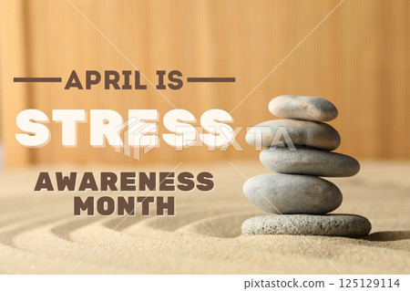 Stress month, balancing stones on sand on wooden background with text 125129114